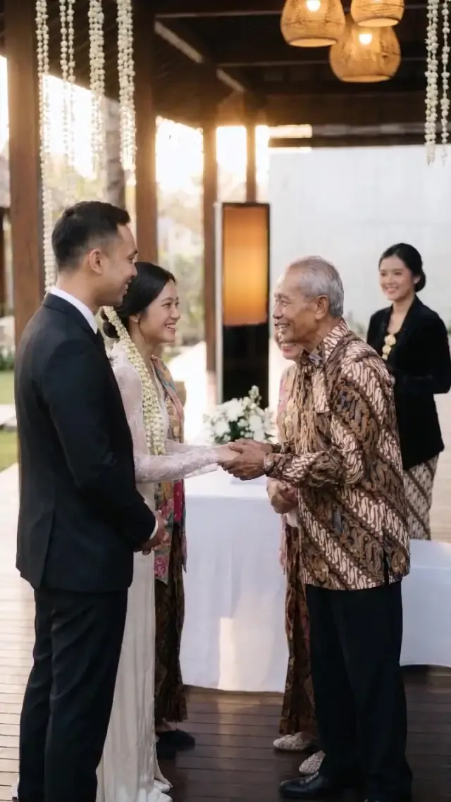 Pengantin menyambut tamu sepuh berbatik di paviliun berhias ronce melati.
